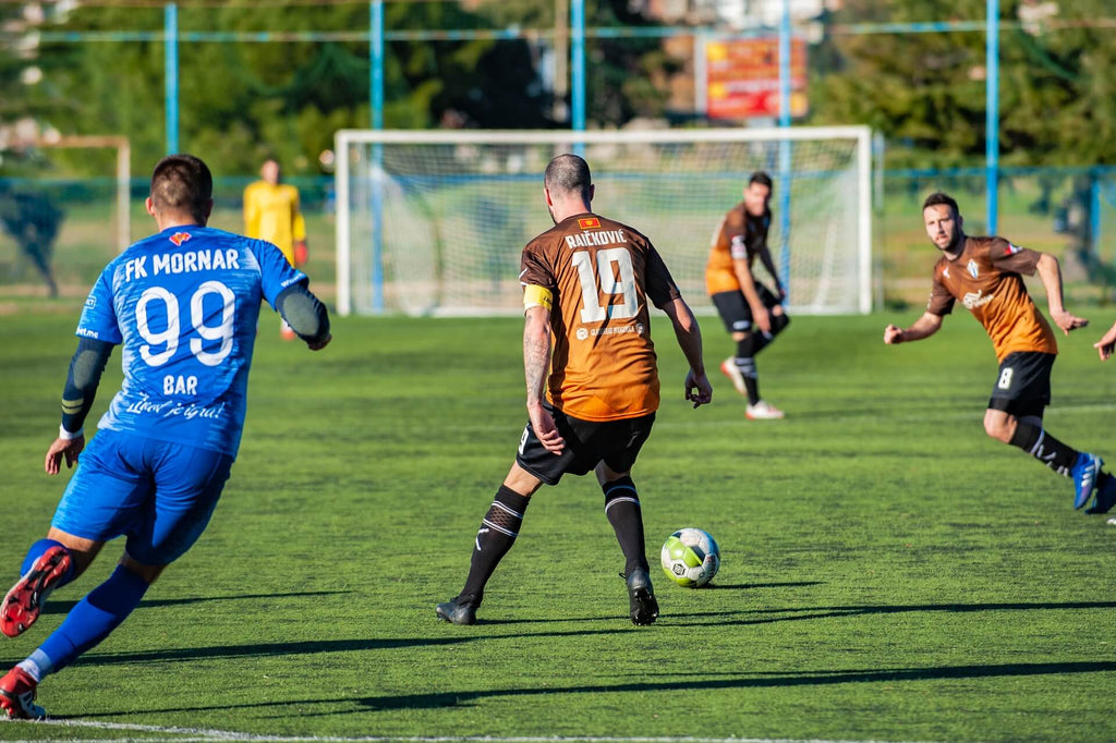 competitive soccer player passing soccer ball on field during game