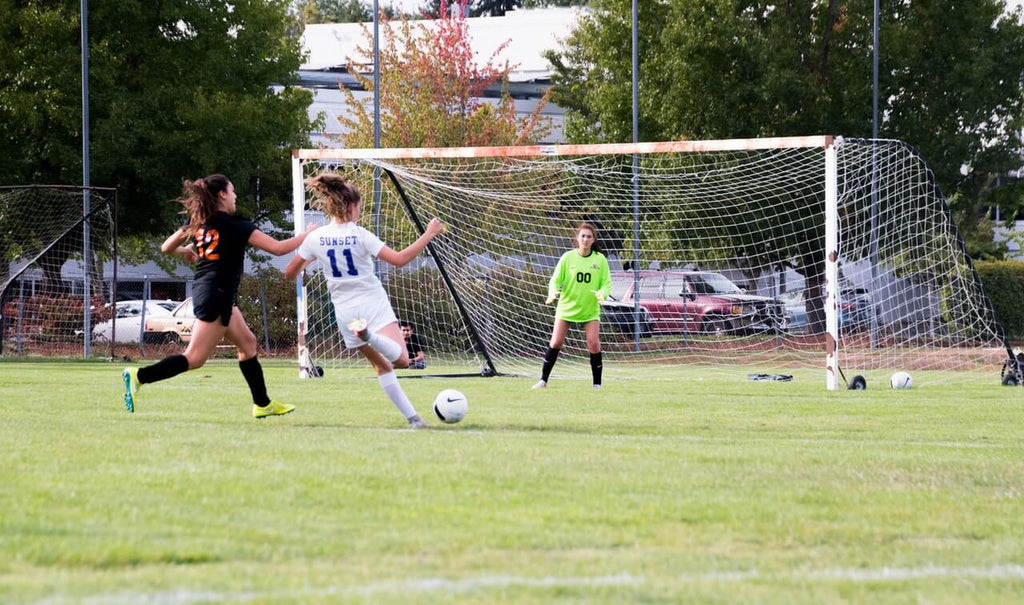 Youth Soccer Figh Girl shooting on football goal in the game