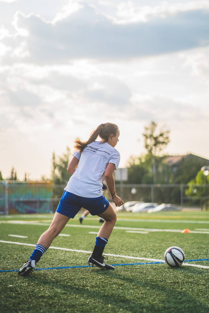 girl soccer player practicing pass and run back drill